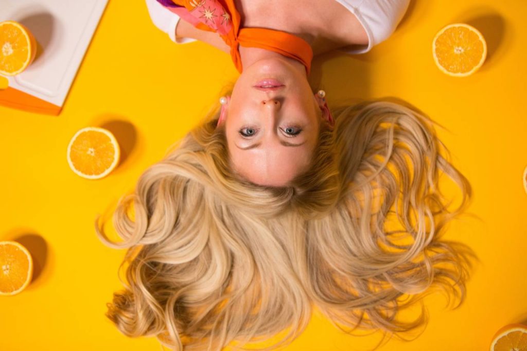 woman with blonde hair oranges around